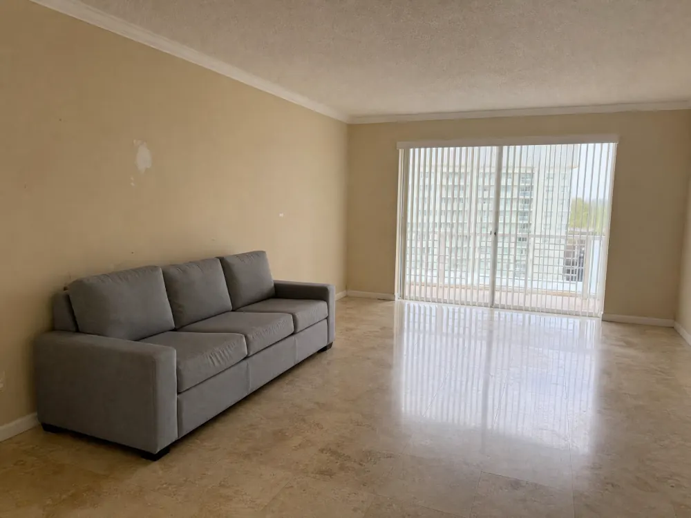 Living room with plain beige painted walls before wallpaper installation