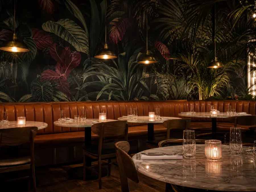 Dark botanical green and oxblood wallcovering in a restaurant dining room