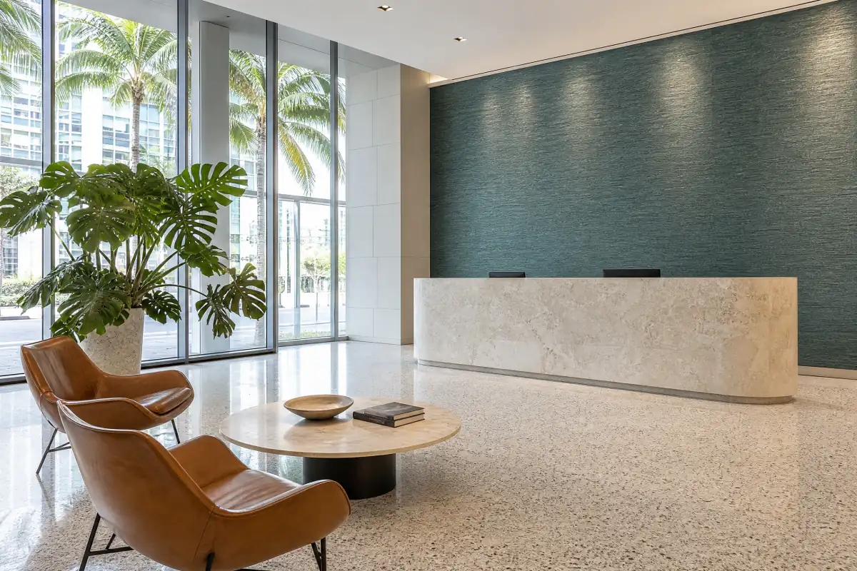 Teal grasscloth wallcovering behind the reception desk of a Miami office tower lobby
